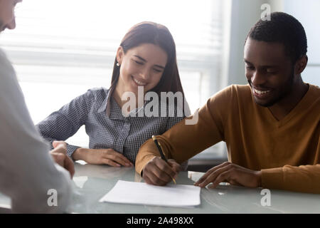 Young smiling woman watching mari signature du contrat. Banque D'Images