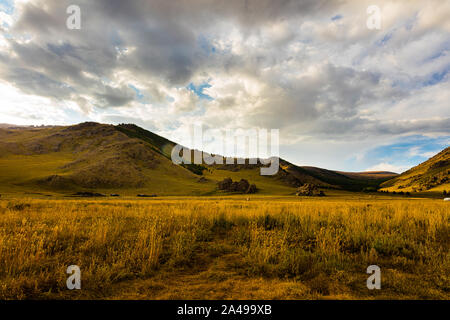 Le soleil se couche en Mongolie , Sunset Paysage photographie dans la steppe mongole à Arhangai-Aimag. Ciel bleu avec nuages blancs et steppe jaune Banque D'Images