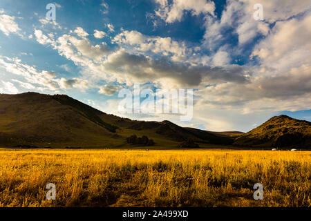 Le soleil se couche en Mongolie , Sunset Paysage photographie dans la steppe mongole à Arhangai-Aimag. Ciel bleu avec nuages blancs et steppe jaune Banque D'Images