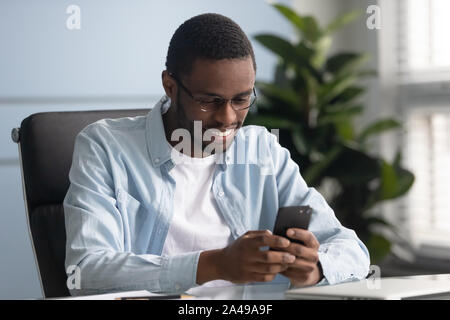 Smiling african american employé en utilisant des applications mobiles. Banque D'Images