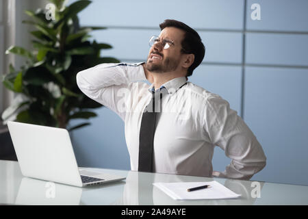 Les jeunes souffrant de mauvaise santé gestionnaire fort mal de dos musculaire. Banque D'Images