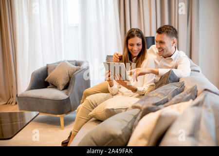 Joli couple à la maison de luxe with digital tablet Banque D'Images