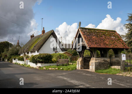 Lychgate de l'église St James et un cottage traditionnel blanc de chaume dans le village d'Avebury, Wiltshire, Angleterre, Royaume-Uni Banque D'Images