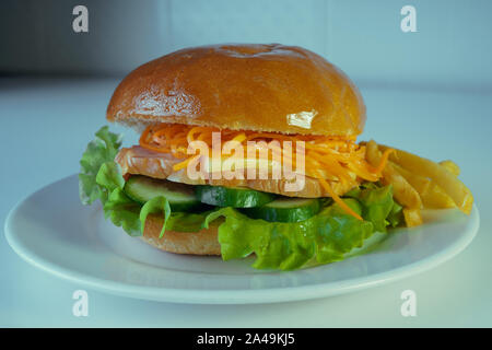 Un grand et savoureux avec un hamburger juteux morceau de poulet, concombres, carottes et coréen du fromage. Sur une assiette de frites. Banque D'Images