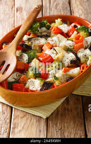 Gratin de pommes de terre saine chaude, carottes, aubergines, poivrons, tomates et fromage close-up dans un plat allant au four, sur la table verticale. Banque D'Images