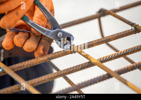 Lier de barres d'armature en acier (barres d'armature) pour la construction. Le fil à l'aide de pinces de serrage une. Banque D'Images