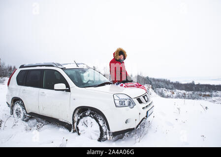 Homme assis sur le capot de la voiture suv avec pavillon d'usa travel concept de voiture. Banque D'Images