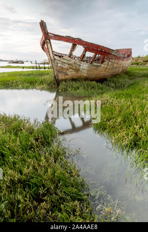 Le cimetière de bateaux de Noirmoutier. L'épave d'un vieux bateau de pêche est échoué sur la végétation qui pousse sur le bord de la vasière Banque D'Images