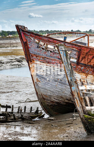 Le cimetière de bateaux de Noirmoutier. La proue de l'épave d'un vieux bateau de pêche en bois échoué sur la vase à marée basse. Banque D'Images
