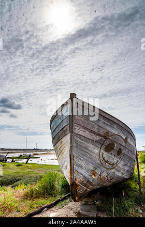 Le cimetière de bateaux de Noirmoutier. La proue de l'épave d'un vieux bateau de pêche en bois se tient sous un ciel nuageux Banque D'Images