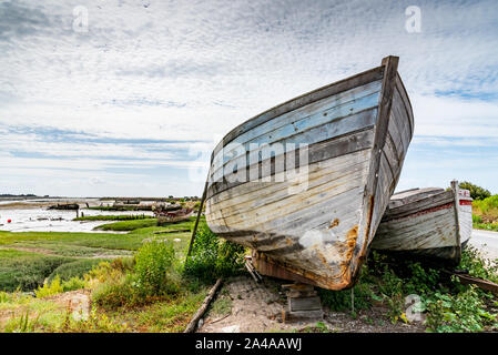 Le cimetière de bateaux de Noirmoutier. La proue de l'épave d'un vieux bateau de pêche en bois se tient sous un ciel nuageux Banque D'Images