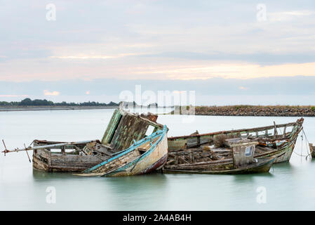 Le cimetière de bateaux de Noirmoutier. Un groupe d'épaves de vieux bateaux de pêche en bois sont empilés et ne pas flotter à marée haute Banque D'Images