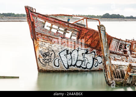 Le cimetière de bateaux de Noirmoutier. La proue de l'épave d'un vieux bateau de pêche en bois bloqués et ne pas flotter à marée haute. Banque D'Images