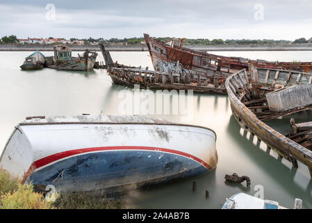 Le cimetière de bateaux de Noirmoutier tôt le matin. Un groupe d'épaves de bateaux de pêche en bois ancien à marée haute Banque D'Images