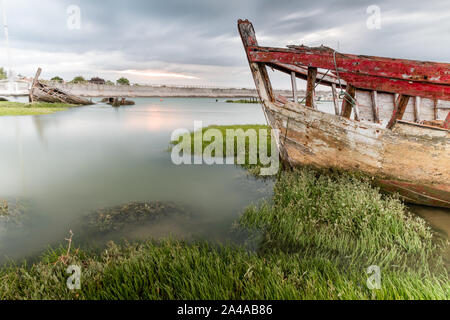 Le cimetière de bateaux de Noirmoutier. L'épave d'un vieux bateau de pêche est échoué sur la végétation qui pousse sur le bord de la vasière Banque D'Images