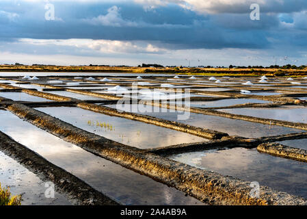 Les marais salants de l'île de Noirmoutier en France. Le soleil se lève sur des étangs, bassins et des tas de sel Banque D'Images