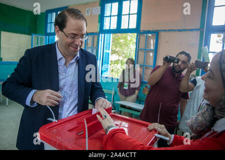 Tunis, Tunisie. 13 Oct, 2019. Le Premier Ministre tunisien Youssef Chahed (L) jette son bulletin de vote pour le deuxième tour des élections présidentielles à Tunis, Tunisie, le 13 octobre 2019. Credit : Adele Ezzine/Xinhua/Alamy Live News Banque D'Images