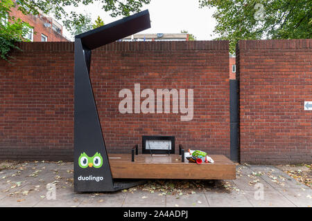 Un banc et un smart Duolingo Strawberry Energy solar powered free mobile point de recharge sur une rue de ville de Londres. Banque D'Images