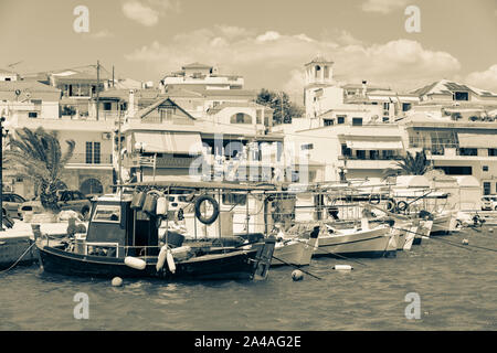 Ermioni Grèce - le 20 juillet 2019 ; Old-fashioned sépia waterfront avec ses bateaux amarrés le long du quai de pêche et les bâtiments de la ville derrière. Banque D'Images