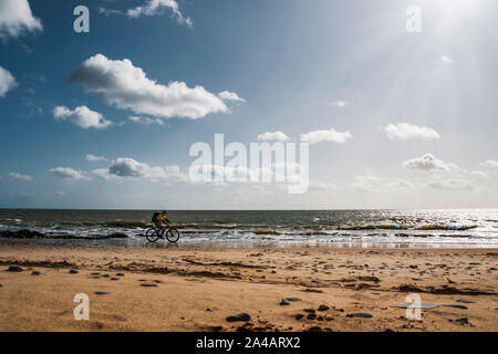 Randonnée à vélo en Irlande. Loisirs de cycliste avec sac à dos et vélo de montagne équitation sur la plage de la mer. Banque D'Images