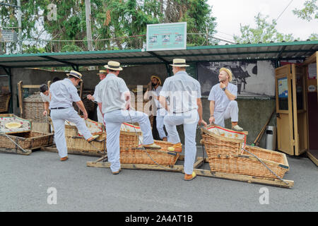 Monte (Funchal, Portugal) - 17 septembre 2018 : Le toboggan les pilotes avec leur panier voitures attendent les touristes au point de début de piste Banque D'Images