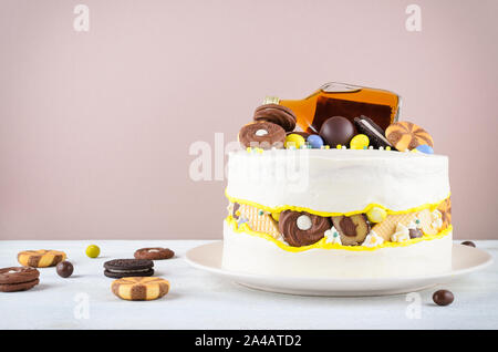 Drôle de gâteau avec une bouteille d'alcool, des bonbons et biscuits Banque D'Images