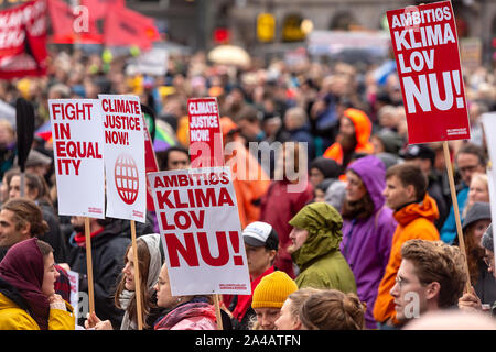 Copenhague, Danemark - 11 octobre 2019 : Des milliers de personnes se retrouvent dans un climat de Mars à la place de l'Hôtel de ville de Copenhague et a exigé une action rapide et les changements climatiques, qui marque la fin de la C40 World Mayors sommet au cours de cette semaine à Copenhague. À droite un panneau avec le texte en anglais : 'loi sur le climat ambitieux maintenant'. Il s'agit d'une demande populaire pour un cadre légal pour l'état des Gouvernements danois efforts climatiques, qui comporte des obligations pour définir les objectifs climatiques contraignants. Banque D'Images