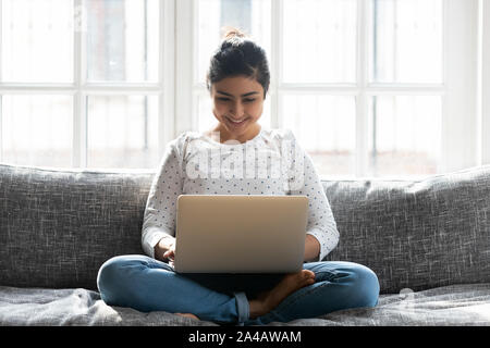 Smiling woman using laptop, bavarder en réseau social Banque D'Images