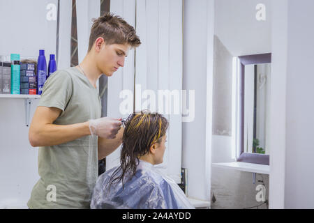 Coiffeur professionnel faisant hairstyle pour client Banque D'Images
