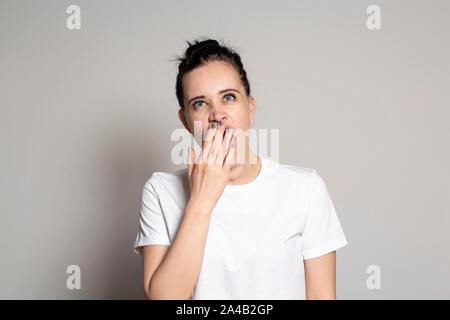 Jeune femme endormie, bâillements et couvre sa bouche avec sa main. Isolé sur fond blanc. Close-up. Banque D'Images