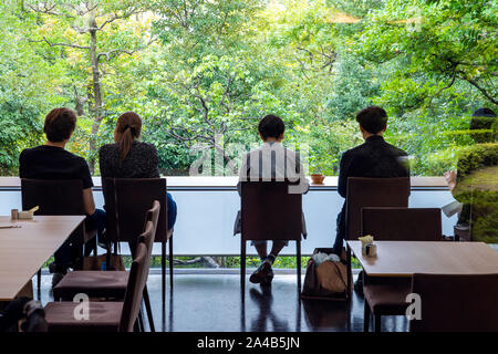 Les gens sont d'un plateau/bouilloire et d'observation de la Nature. Les hommes et les femmes regardent le jardin verdoyant. Couple profitent de forêt. Banque D'Images