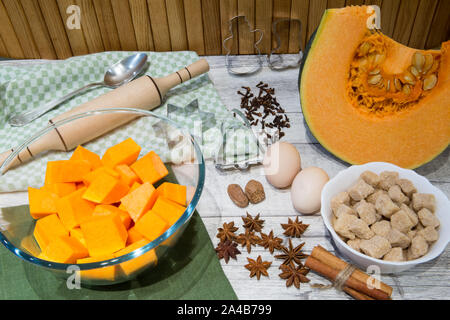 Citrouille fraîche (squash) sur une table de cuisine avec des ingrédients pour la cuisine. Beaucoup d'épices, les noix et les oeufs, sucre brun de canne. Banque D'Images