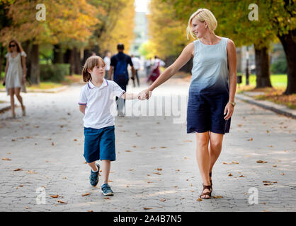 Spécial enfants heureux et sa maman à pied le long d'un sentier du parc au début de l'automne Banque D'Images