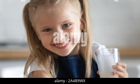 Head shot portrait of cute little girl avec moustache de lait Banque D'Images