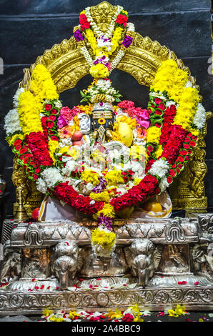 KUALA LUMPUR, MALAISIE - le 18 décembre 2018 : Très belle statue du dieu hindou Sri avec Ganesar Kortumalai coloré décoration florale dans la cour du temple Hill. Banque D'Images