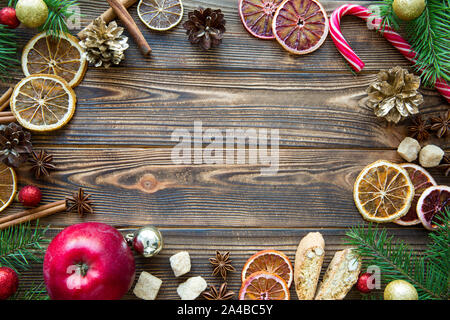 Vacances de Noël tableau sweet arrière-plan. Délicieux cadre fait de cookies, les oranges, le sucre de canne, et des bonbons de Noël spicea sucette stick. Sapin branc Banque D'Images