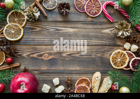 Vacances de Noël tableau sweet arrière-plan. Délicieux cadre fait de cookies, les oranges, le sucre de canne, et des bonbons de Noël spicea sucette stick. Sapin branc Banque D'Images