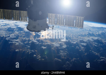 Chaînes de l'espace au-dessus de la terre, avec la réflexion du soleil.éléments de cette image ont été fournies par la NASA Banque D'Images