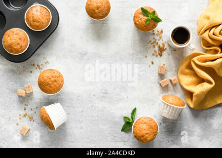 Des muffins dans les tasses de papier sur fond de béton. Muffins à la vanille. Top View copy space Banque D'Images