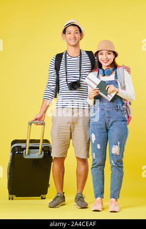 Heureux les jeunes voyageurs asiatiques avec grosse valise, appareil photo numérique, passeport et billet d'avion Banque D'Images