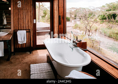 JUN 20, 2011 Tanzanie - salle de bain en plein air avec une baignoire de luxe avec vue sur la forêt - African Safari camp Boho décoration d'intérieur en bois avec mur de bambou. Banque D'Images