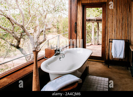 JUN 20, 2011 Tanzanie - salle de bain en plein air avec une baignoire de luxe avec vue sur la forêt - African Safari camp Boho décoration d'intérieur en bois avec mur de bambou. Banque D'Images