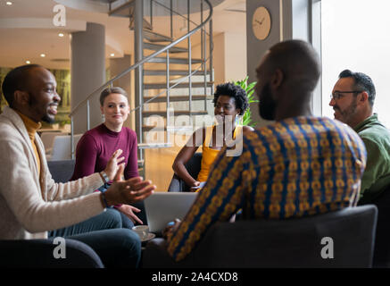Groupe d'hommes d'affaires sud-africaine diversifiée ayant une franche rencontre dans un espace de travail moderne Banque D'Images