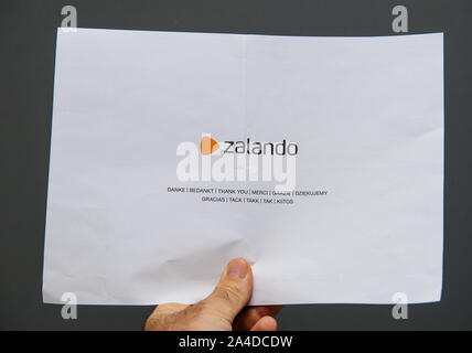 Paris, France - Sep 13, 2019 : man hand holding Zalando lettre de remerciements avec logotype de la site de magasinage en ligne avec Merci message dans toutes les langues européennes Banque D'Images
