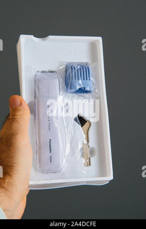 Paris, France - Sep 13, 2019 : Man hand holding femmes ES246 Panasonic Tondeuse Bikini et Shaper appareil dans boîte en carton en plastique pendant unboxing Banque D'Images