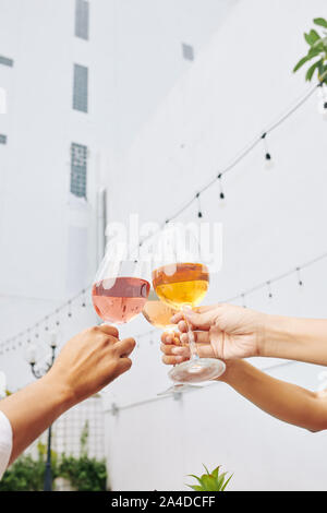 Mains d'invités de partie grillage avec des lunettes de vin rose Banque D'Images