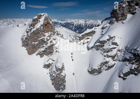 Quatre skieurs de randonnée une forte pente dans l'arrière-pays du Gastein ski area, Salzbourg, Autriche Banque D'Images