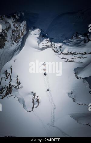 Quatre skieurs de randonnée une forte pente dans l'arrière-pays du Gastein ski area, Salzbourg, Autriche Banque D'Images