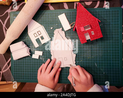 Girl making a maison blanche d'artisanat de Noël Banque D'Images