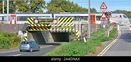 Départ du train de passagers plus Anglia Ely railway station crossing road bridge faible marquage de danger avertissement symboles & Cambridgeshire England UK Banque D'Images